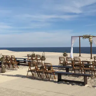 Beachfront wedding ceremony with wooden benches and white gazebo at Paradisus Los Cabos, Cabo San Lucas