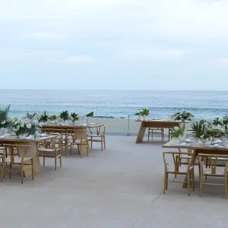 Outdoor wedding reception with wooden tables and white floral centerpieces at Paradisus Los Cabos, Cabo San Lucas