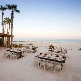 Outdoor wedding reception setup on a terrace overlooking the beach at Paradisus Los Cabos, Cabo San Lucas