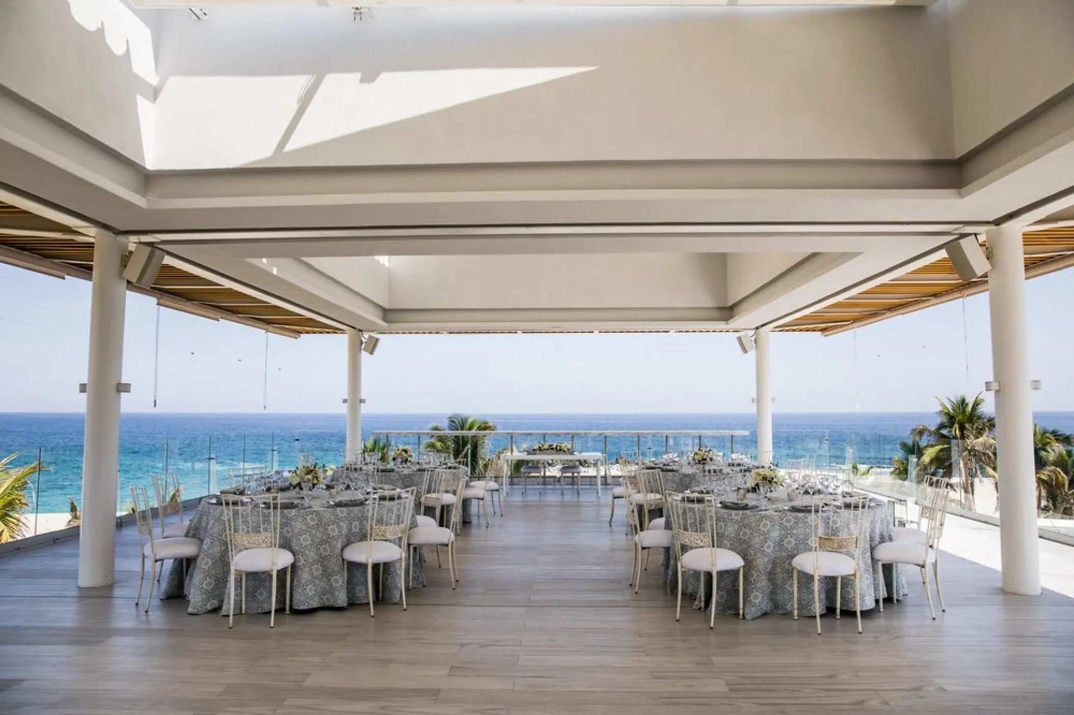 Oceanfront wedding reception with blue patterned linens on a covered terrace at Paradisus Los Cabos, Cabo San Lucas