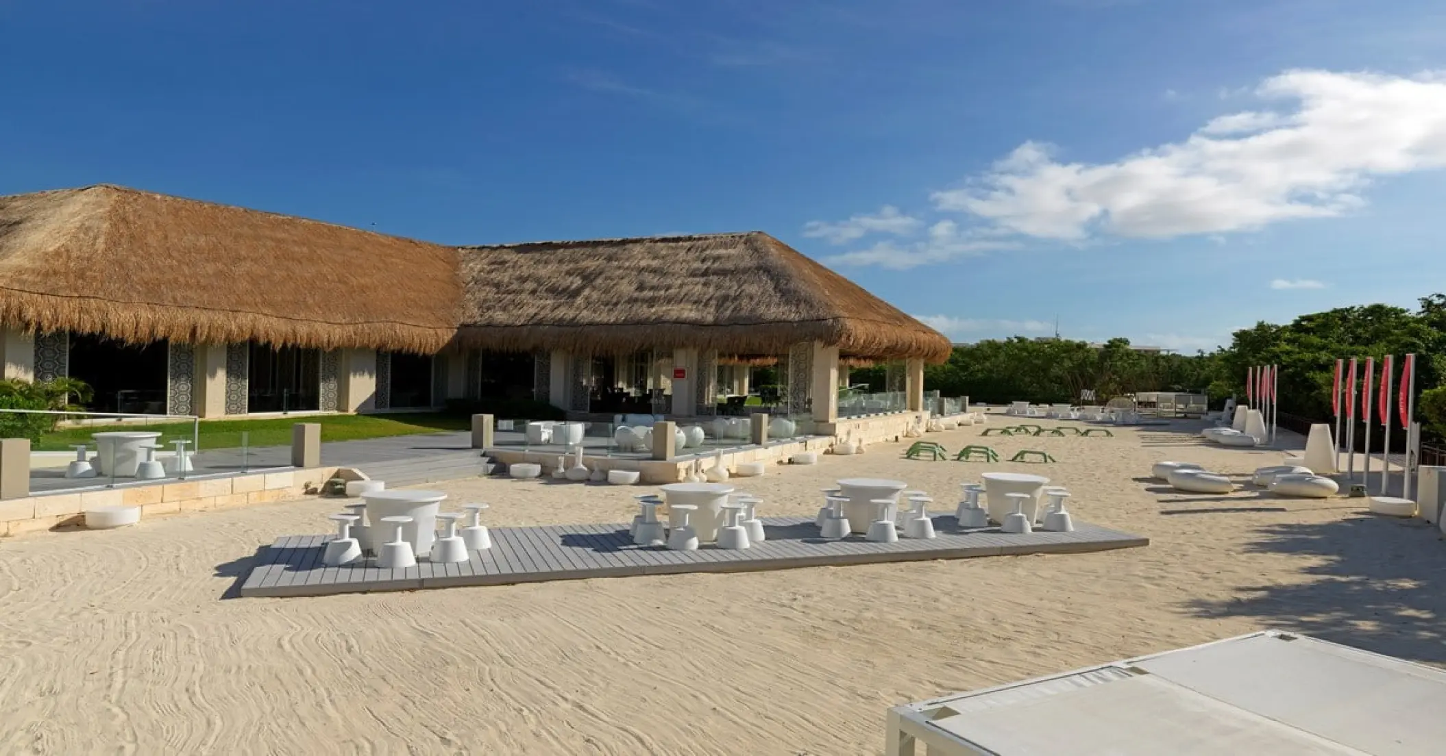 Outdoor beach lounge with white tables and chairs at Paradisus La Perla, Playa Del Carmen