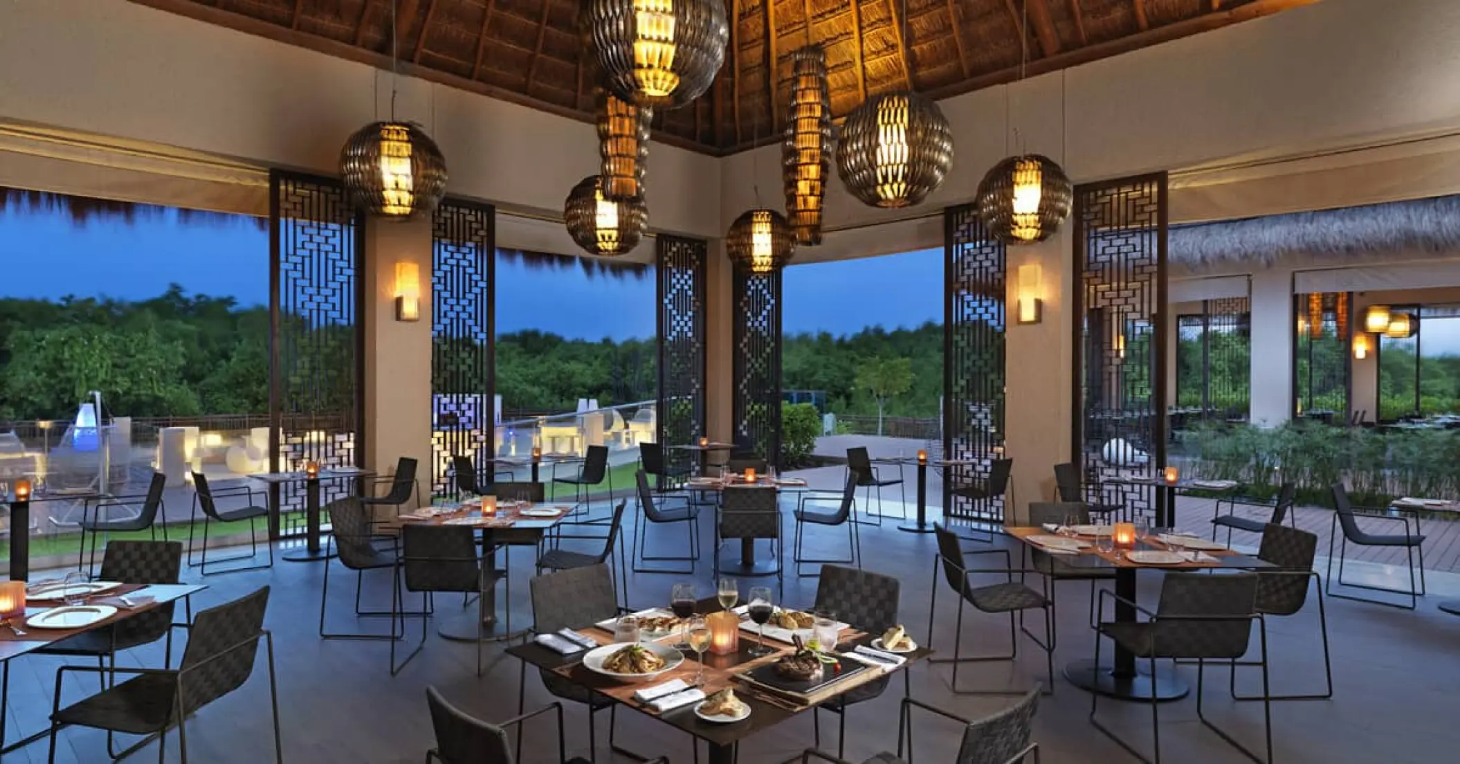 Open-air grill restaurant with modern lighting at Paradisus Playa Del Carmen