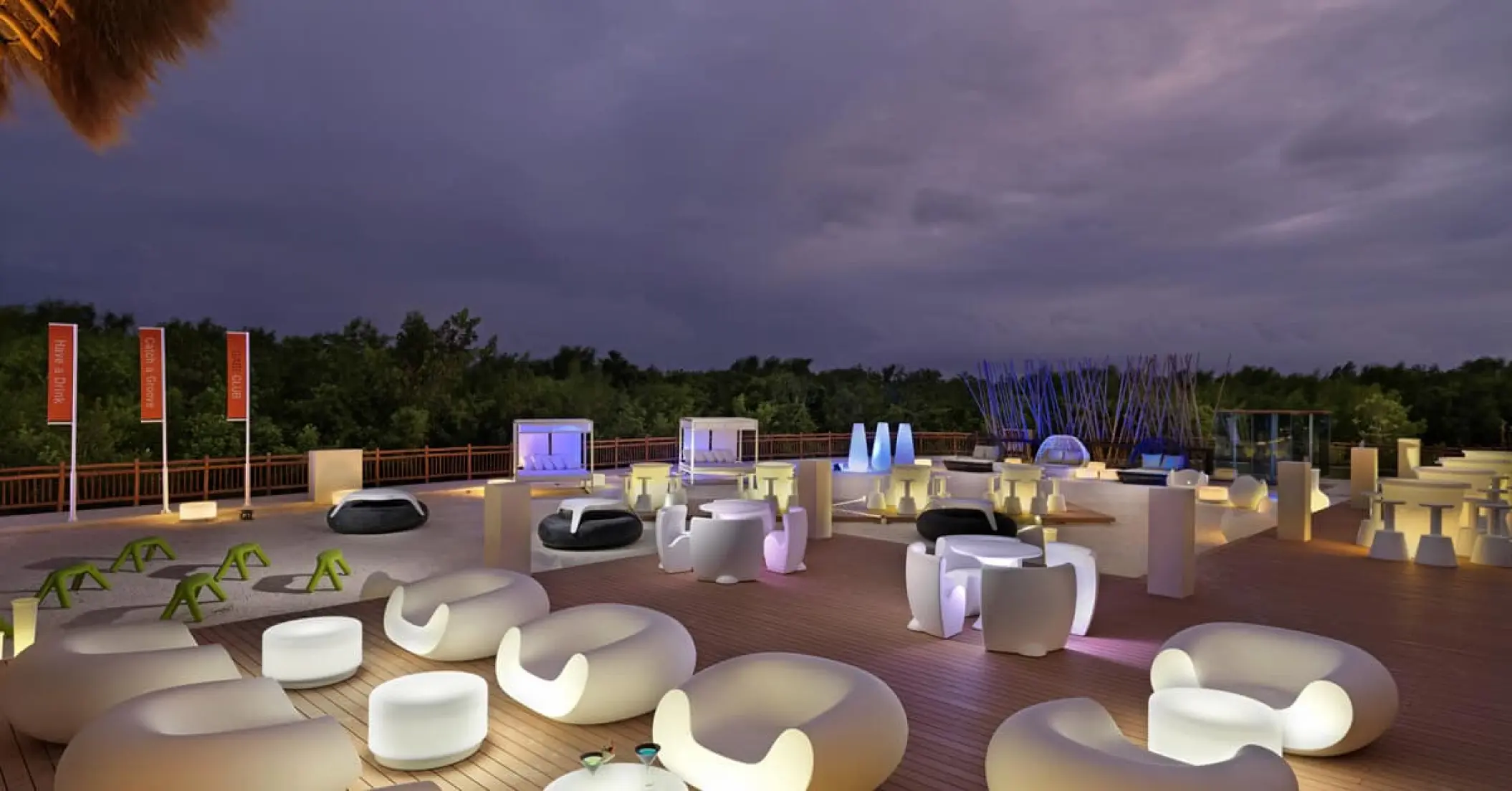 Illuminated outdoor lounge area at dusk at Paradisus Playa Del Carmen