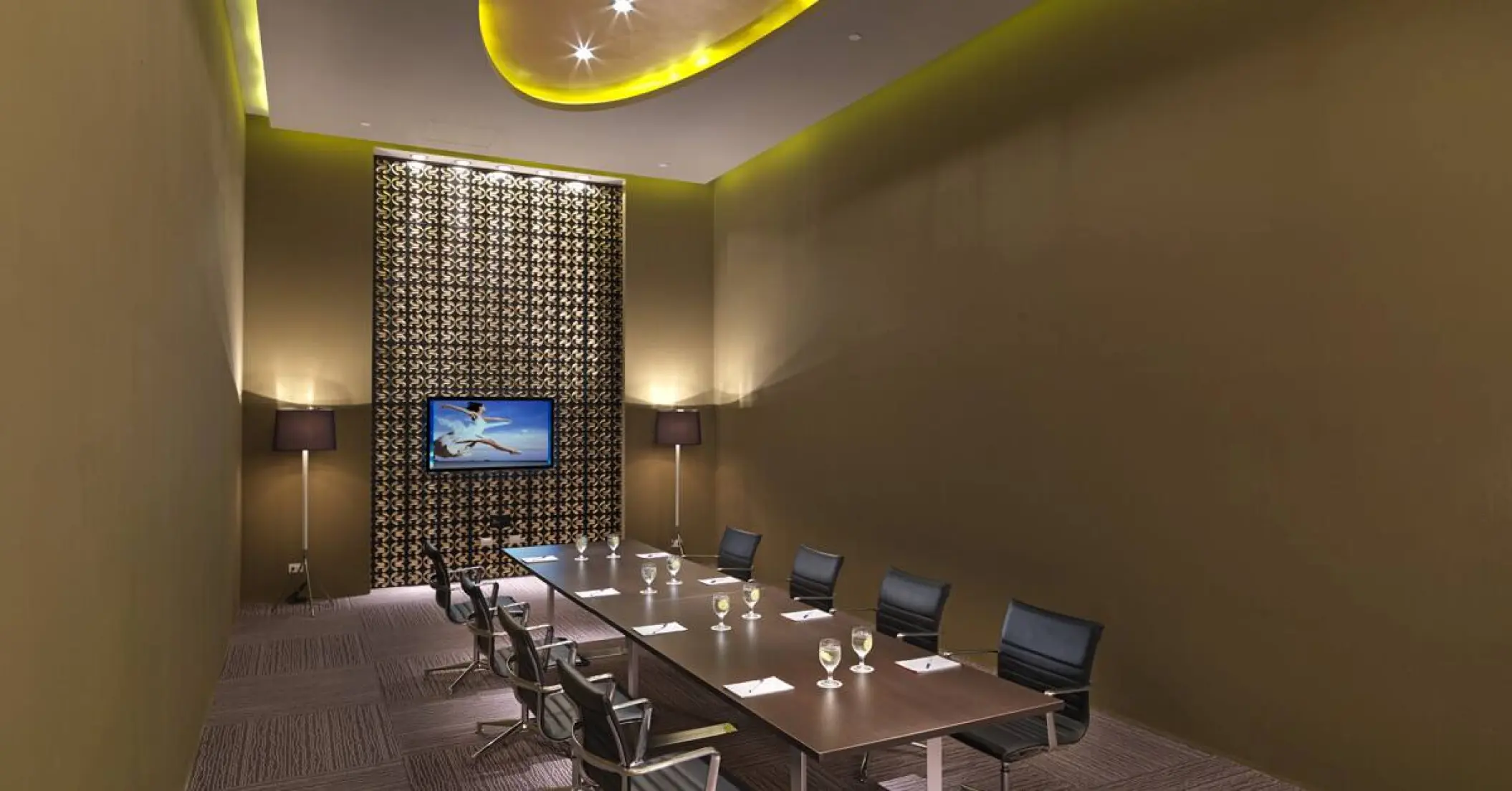 Modern meeting room with a long conference table and screen at Paradisus Playa Del Carmen
