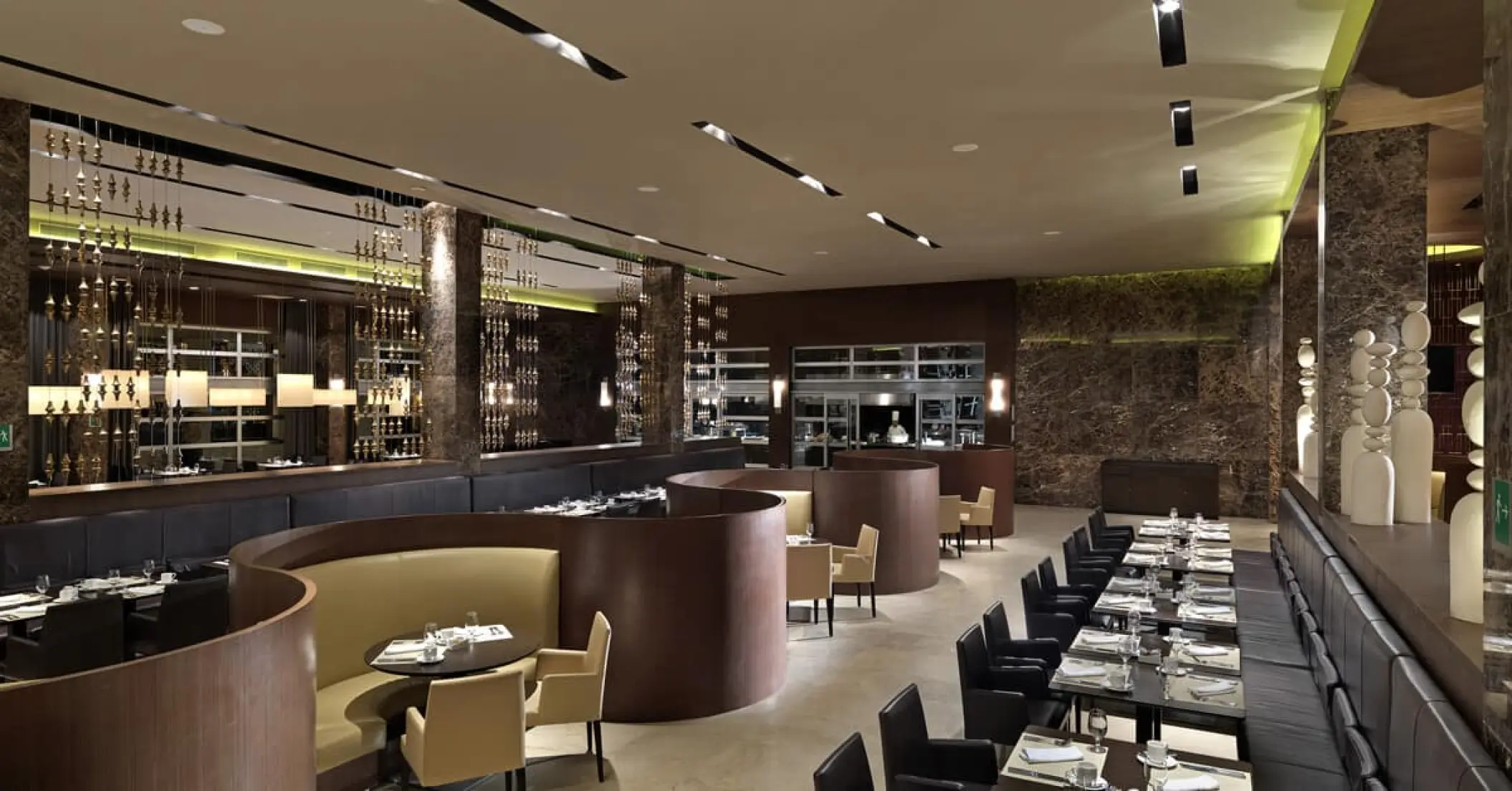 Naos restaurant dining room with curved booths and modern lighting at Paradisus Playa Del Carmen