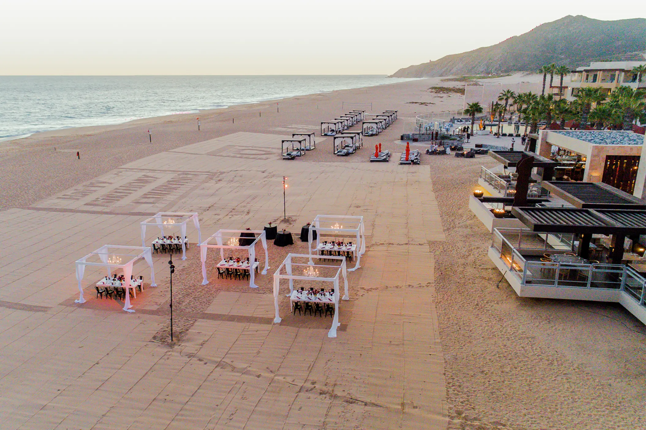 Beachfront wedding reception setup with white cabanas at Pueblo Bonito Pacifica, Cabo San Lucas