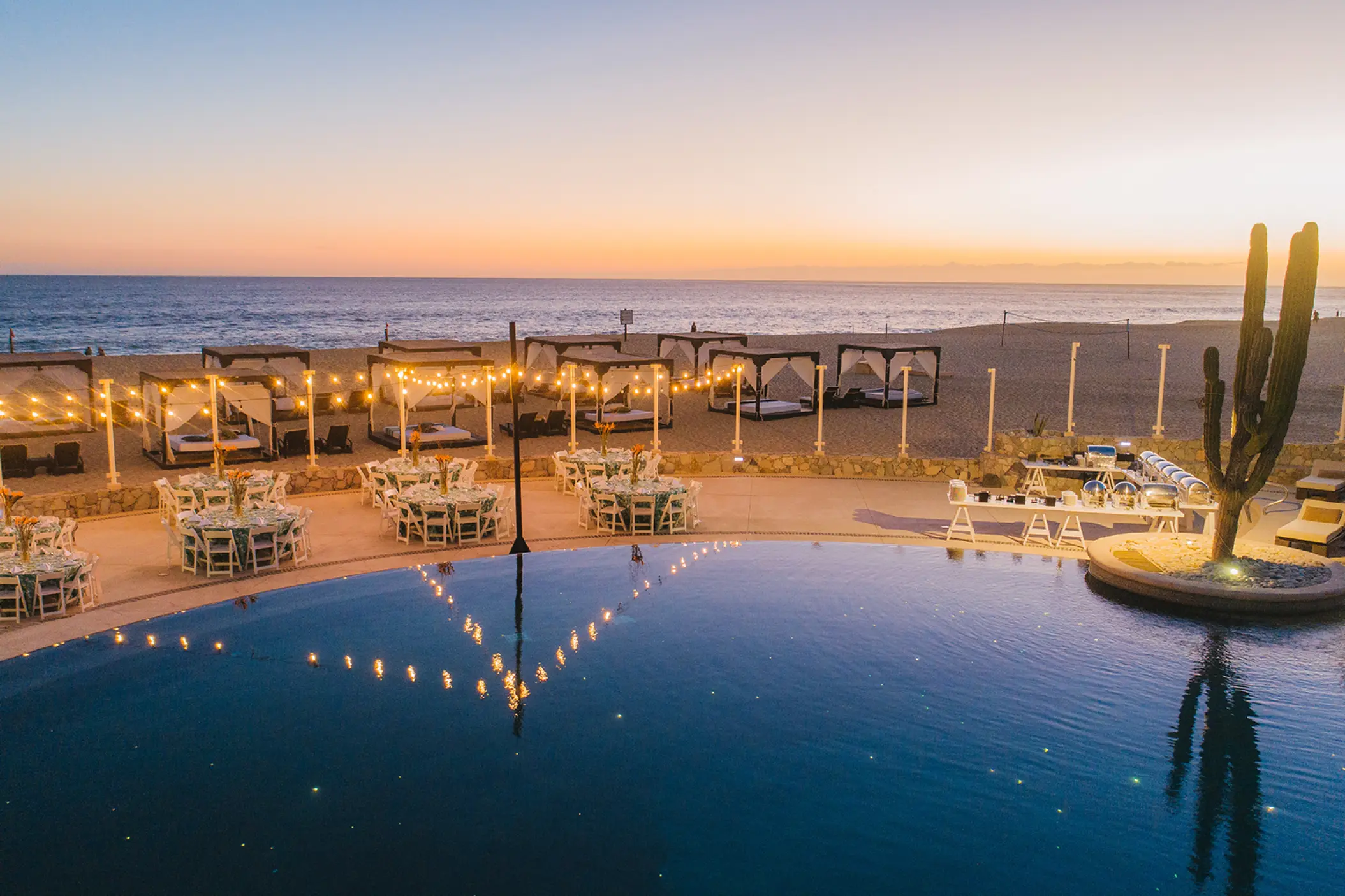 Terrace wedding reception with string lights by the pool at Pueblo Bonito Pacifica, Cabo San Lucas