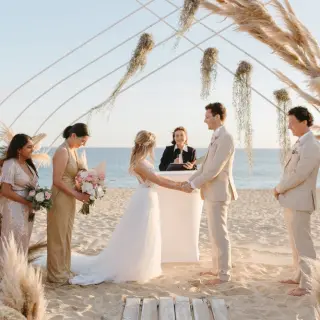 Beachfront wedding ceremony with pampas grass arch at Pueblo Bonito Pacifica, Cabo San Lucas