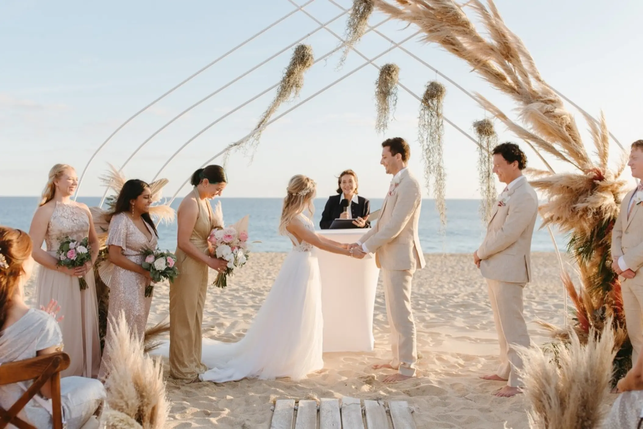 Beachfront wedding ceremony with pampas grass arch at Pueblo Bonito Pacifica, Cabo San Lucas