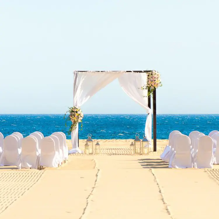 Beachfront wedding ceremony with white draped arch at Pueblo Bonito Pacifica, Cabo San Lucas
