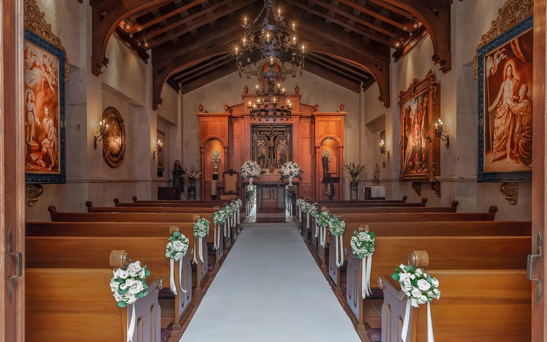 Chapel wedding ceremony venue with wooden pews and floral aisle decor at Pueblo Bonito Sunset Beach, Cabo San Lucas