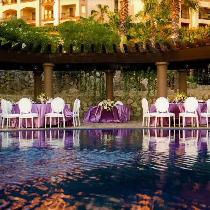 Outdoor wedding reception with purple linens under a pergola at Pueblo Bonito Sunset Beach, Cabo San Lucas