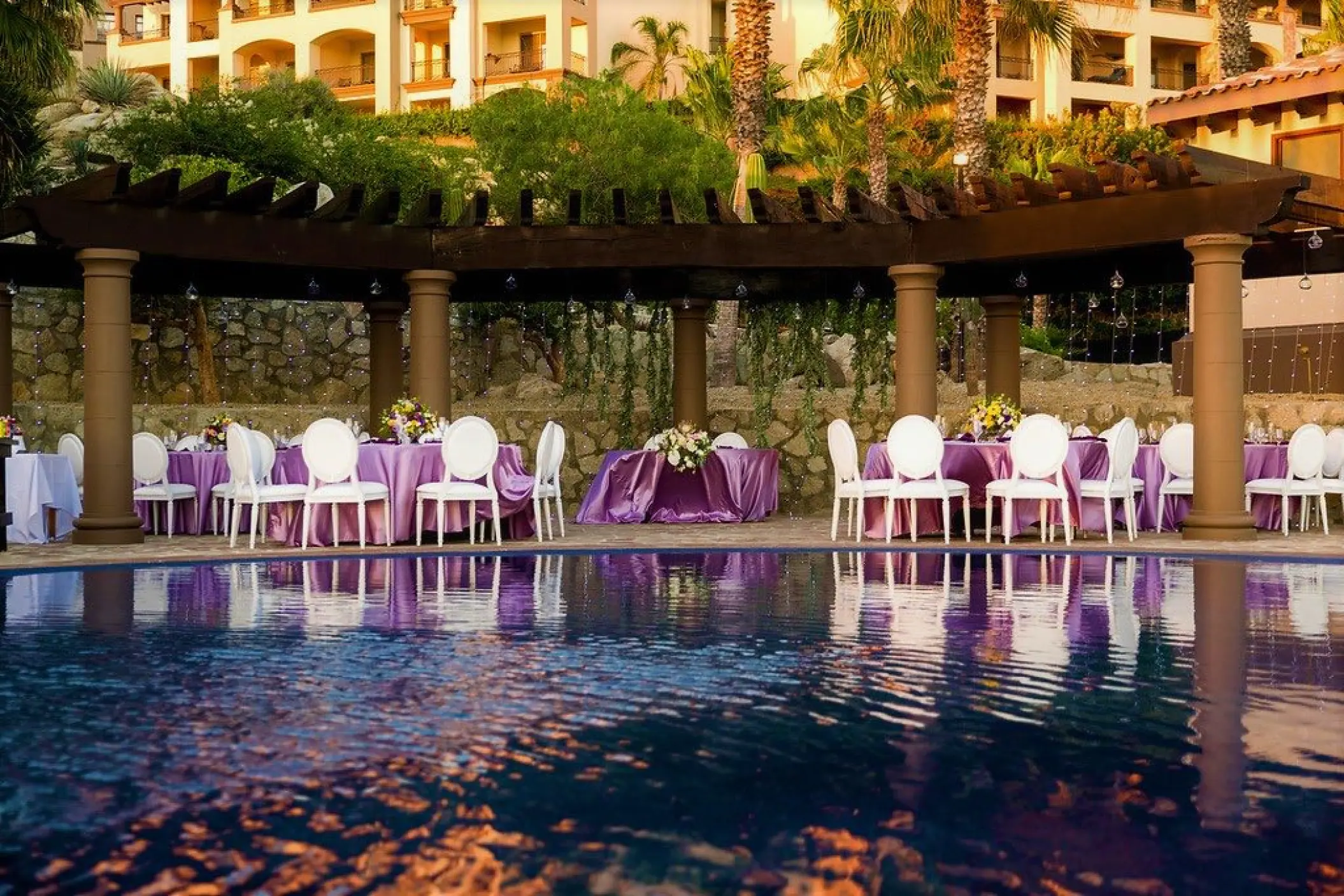 Outdoor wedding reception with purple linens under a pergola at Pueblo Bonito Sunset Beach, Cabo San Lucas