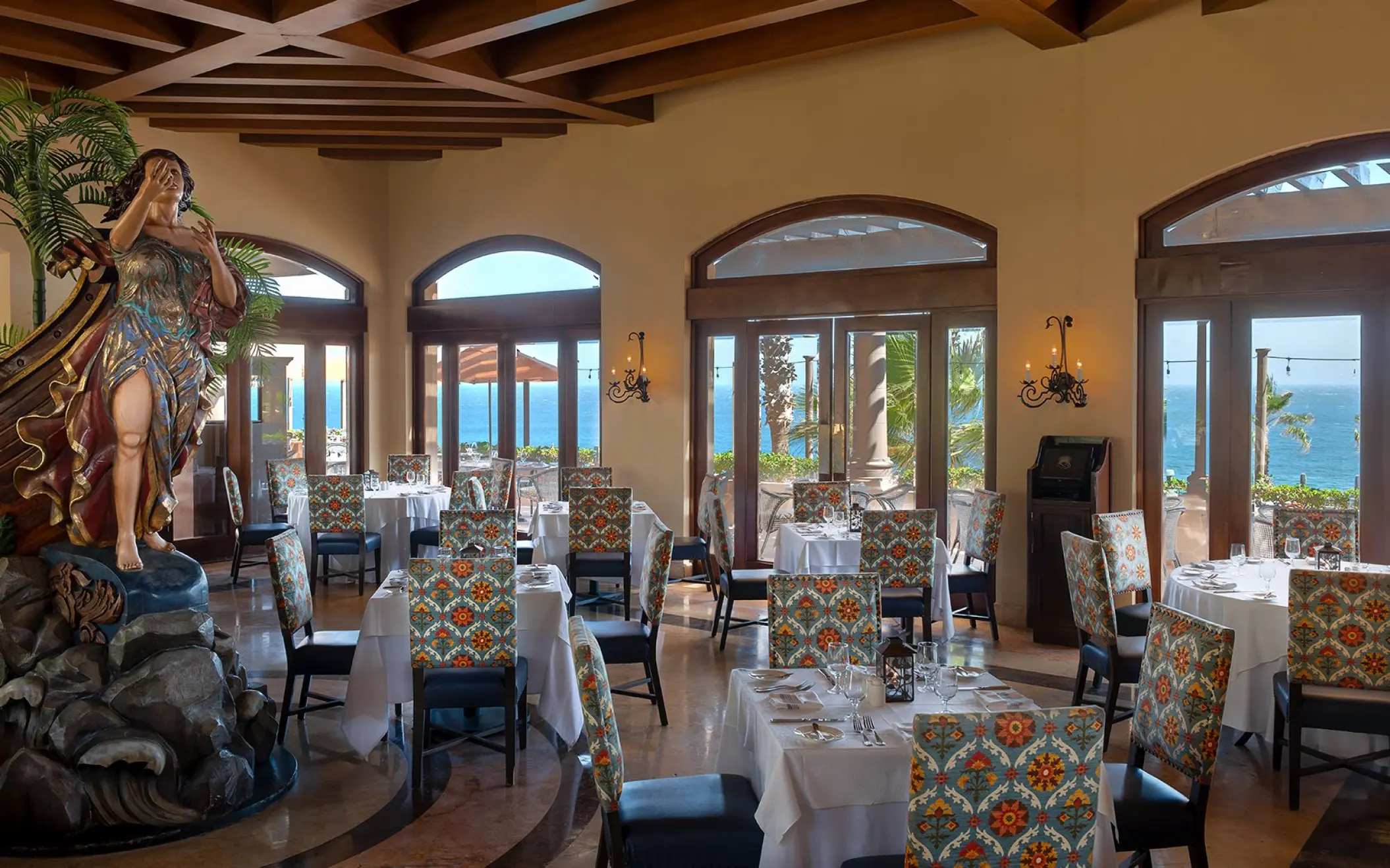 Elegant restaurant interior at Pueblo Bonito Sunset Beach with ocean views and patterned chairs, Cabo San Lucas