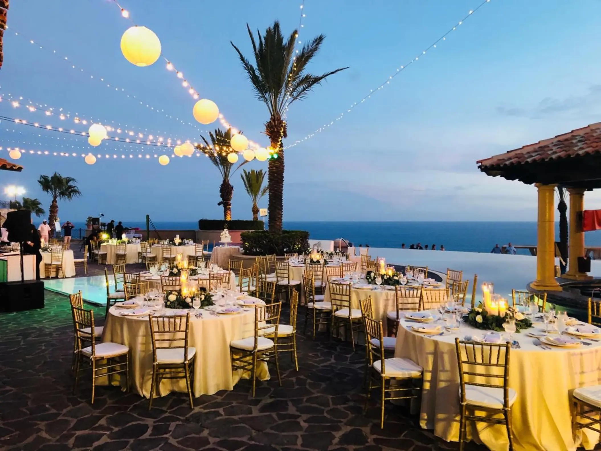 Outdoor wedding reception with string lights and round tables at Pueblo Bonito Sunset Beach, Cabo San Lucas