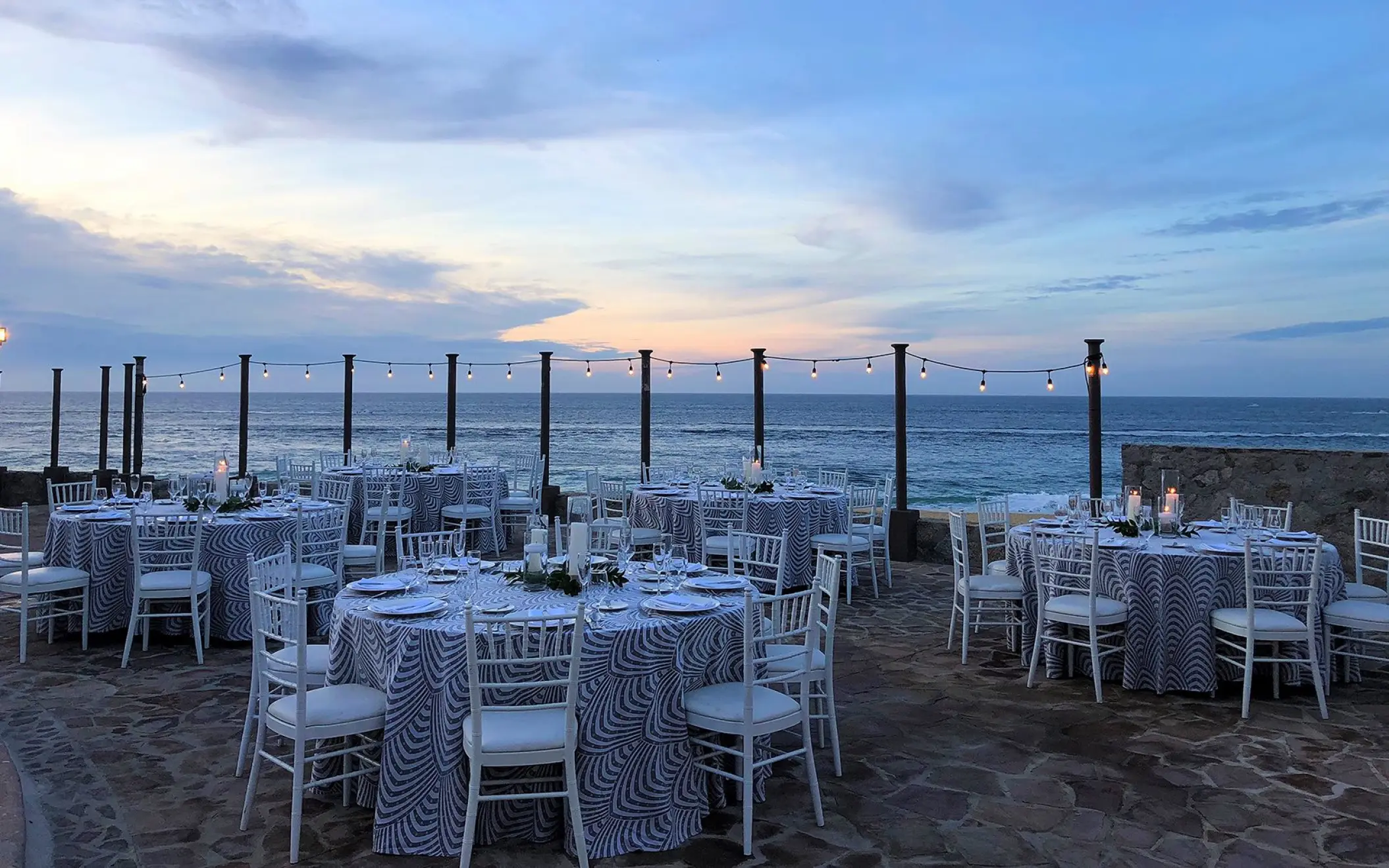 Oceanfront wedding reception with blue patterned tablecloths at Pueblo Bonito Sunset Beach, Cabo San Lucas