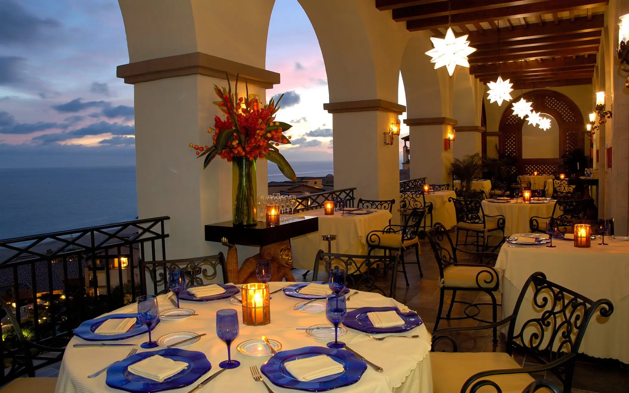 Outdoor terrace restaurant at Pueblo Bonito Sunset Beach with ocean views at dusk, Cabo San Lucas