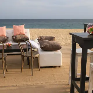 Beachfront wedding reception lounge with white sofas and high-top tables at Pueblo Bonito Sunset Beach, Cabo San Lucas