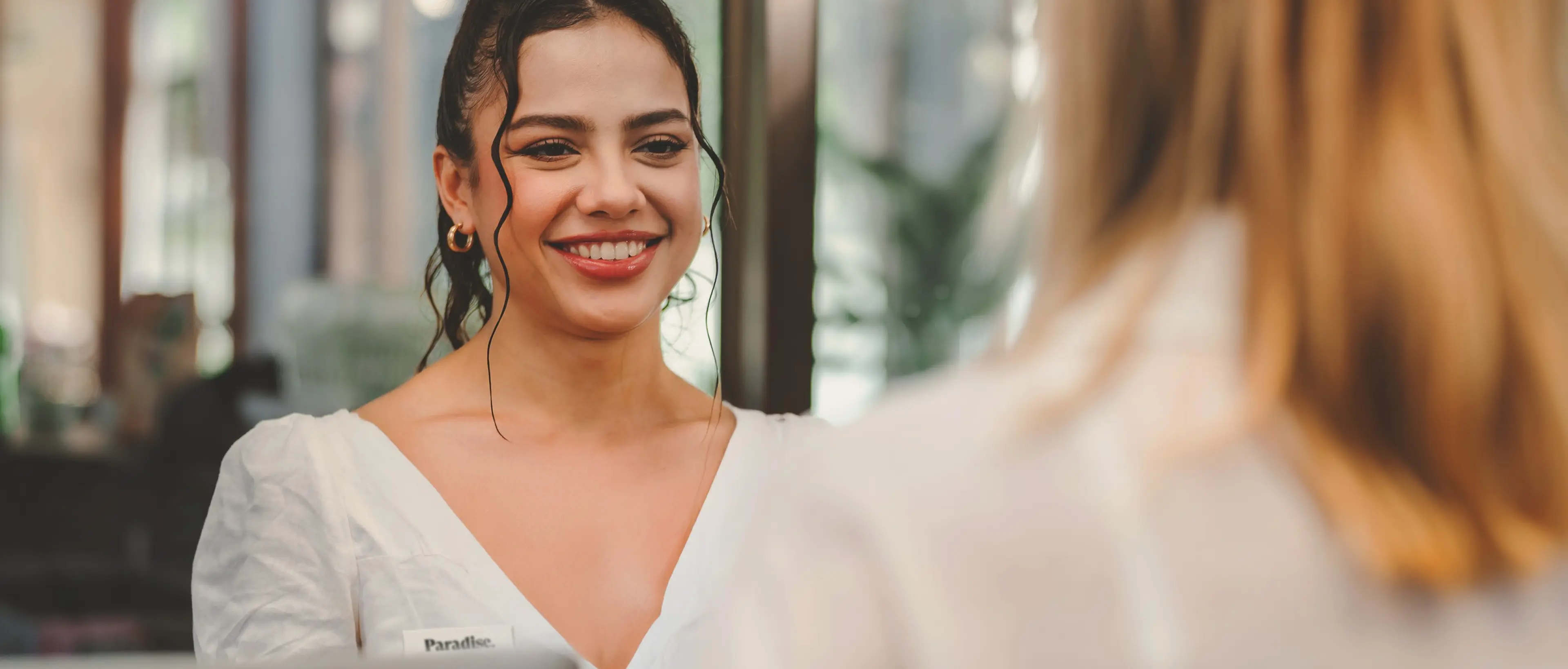 Paradise Weddings planner smiling while assisting a client at a help desk
