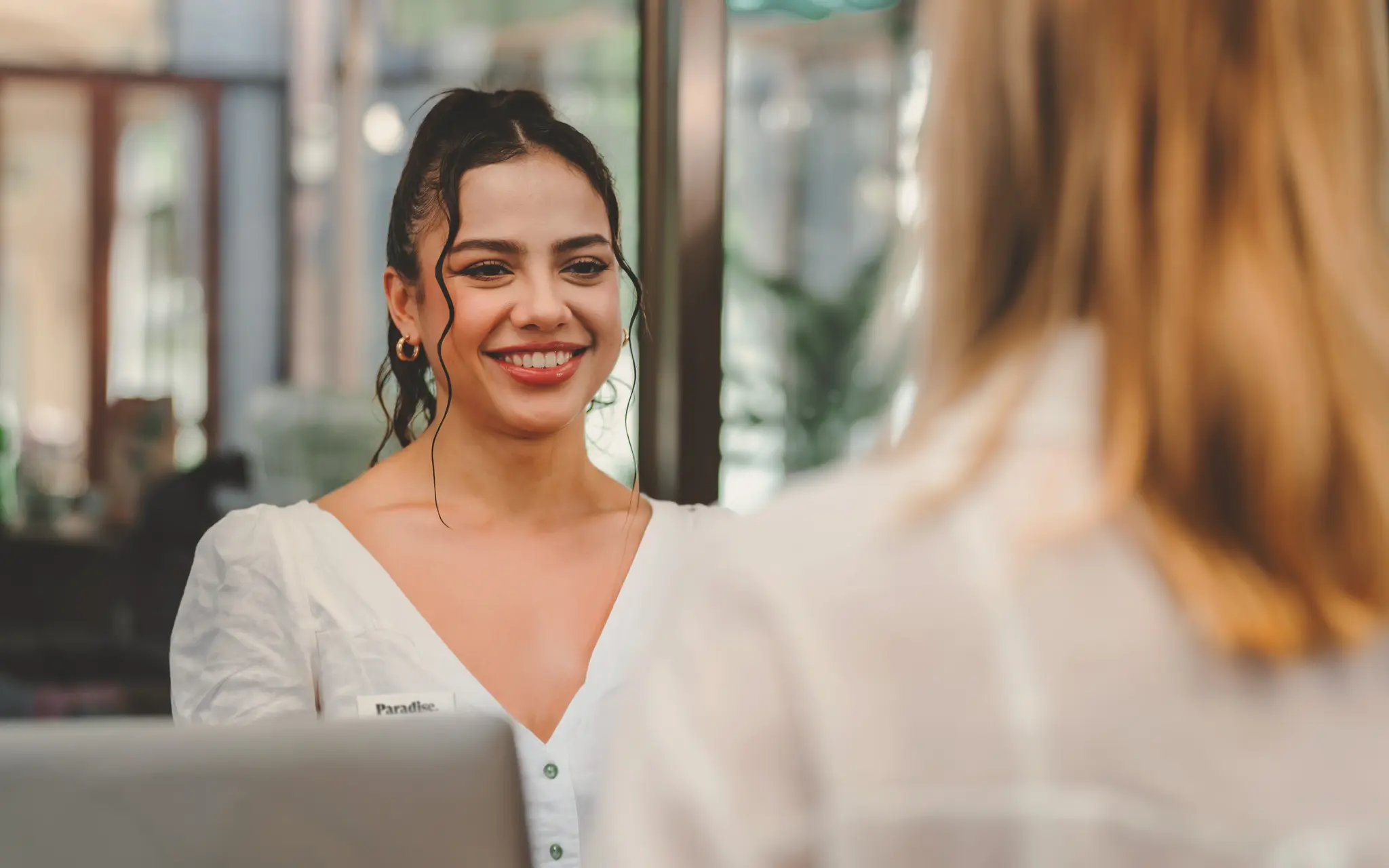 Paradise Weddings planner smiling while assisting a client at a help desk
