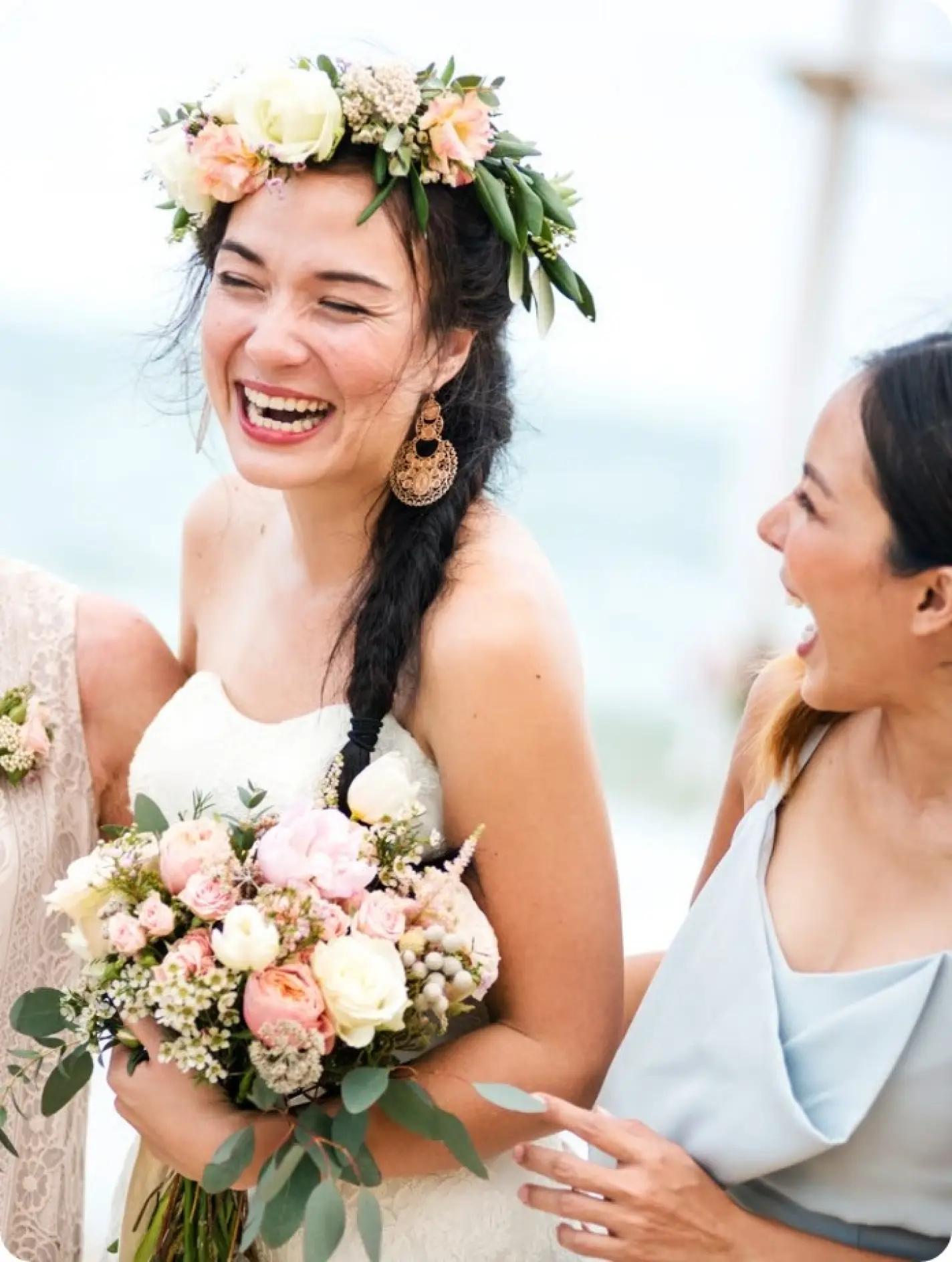 Laughing bride wearing a flower crown and holding a bouquet at a destination wedding