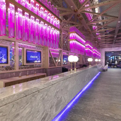 Planet Hollywood Adult Scene Cancun lobby with neon purple lighting and marble front desk
