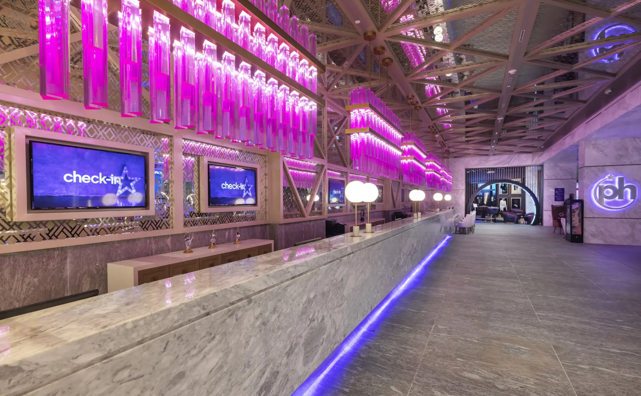 Planet Hollywood Adult Scene Cancun lobby with neon purple lighting and marble front desk