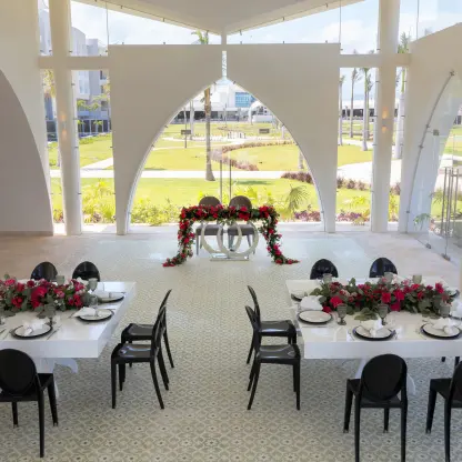 Indoor wedding reception with white tables and black chairs at Planet Hollywood Adult Scene Cancun