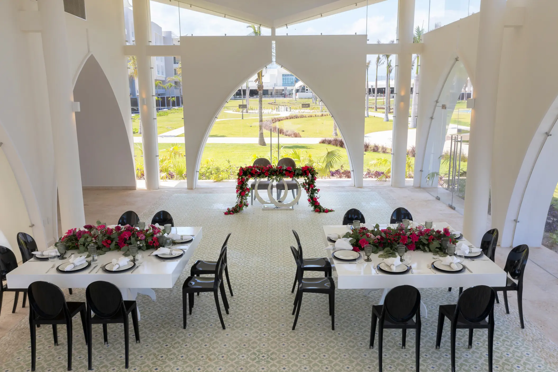 Indoor wedding reception with white tables and black chairs at Planet Hollywood Adult Scene Cancun