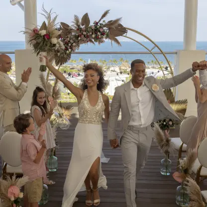 Newlywed couple celebrating at a rooftop wedding ceremony at Planet Hollywood Cancun