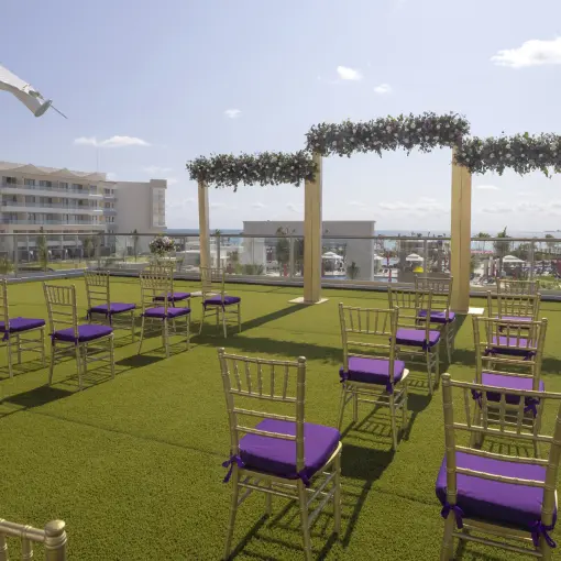 Rooftop terrace wedding ceremony setup with purple chairs at Planet Hollywood Cancun