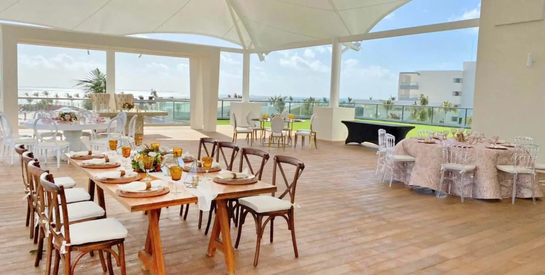 Rooftop wedding reception with decorated tables under a white canopy at Planet Hollywood Cancun
