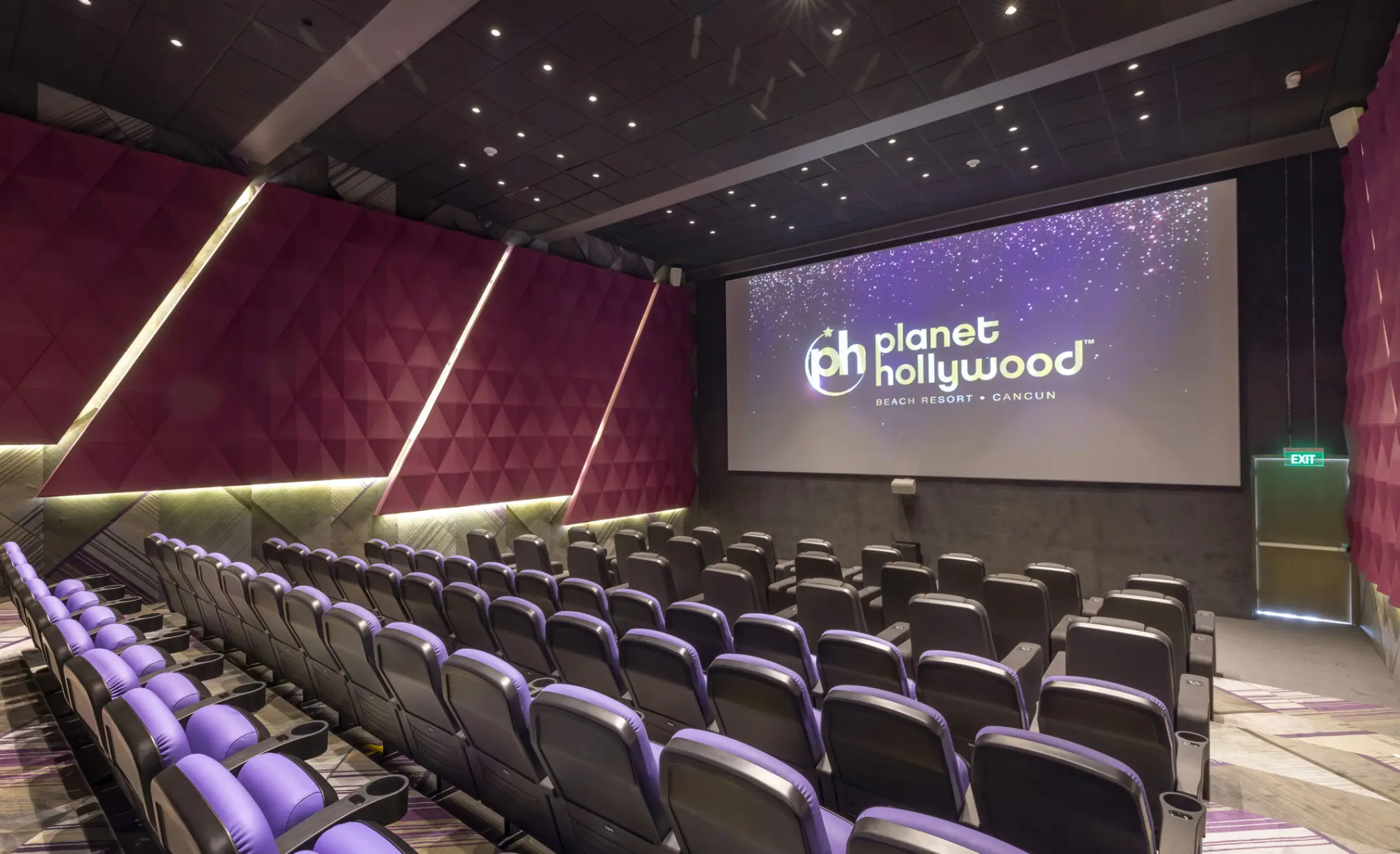 Movie theater with purple seating and planet hollywood logo on the screen at Planet Hollywood Cancun