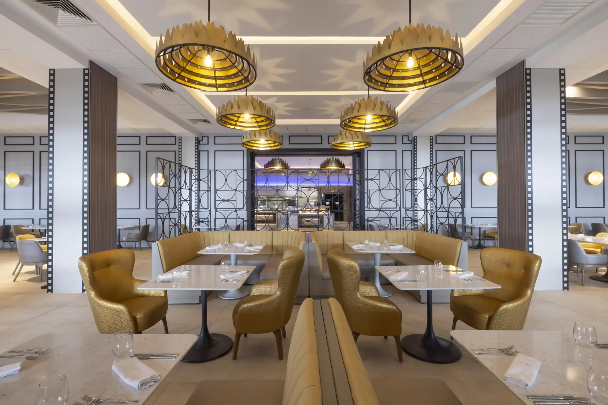 Modern dining room with gold chairs and crown light fixtures at Planet Hollywood Cancun