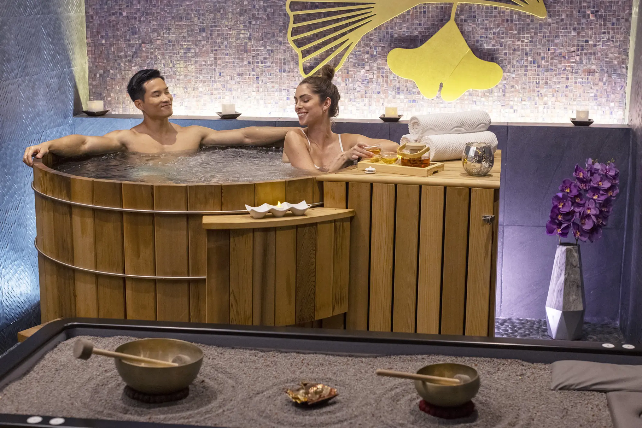 Couple relaxing in a wooden hot tub at the Planet Hollywood Cancun spa, Cancun