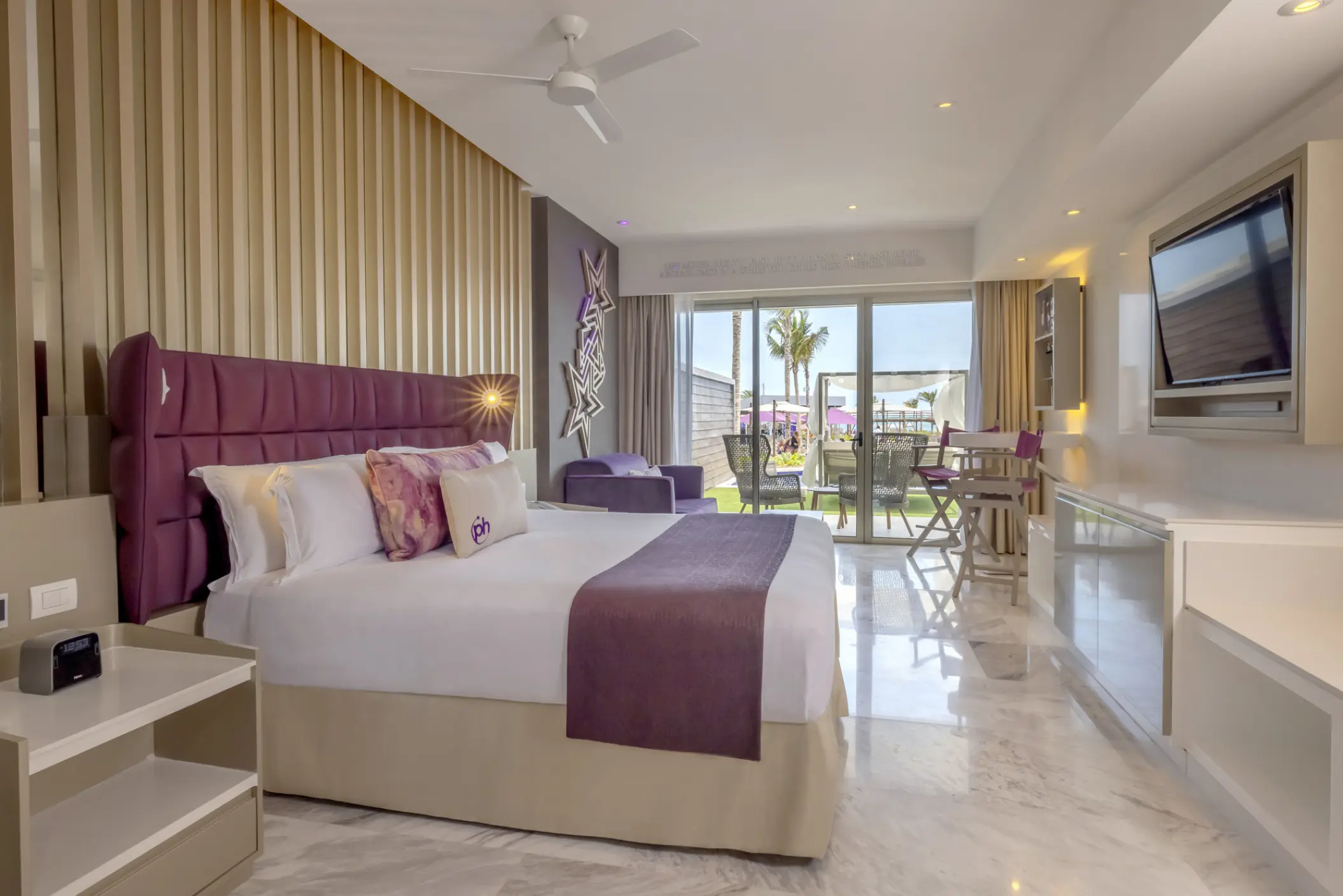 Modern guest suite with purple accents and garden access at Planet Hollywood Cancun