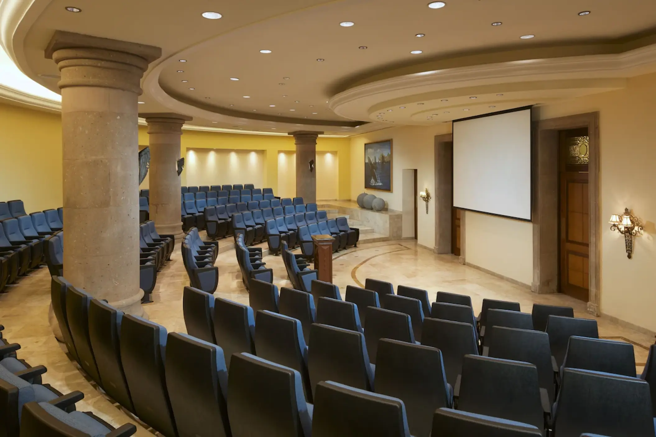 Indoor theater with tiered seating and projector screen at Playa Grande Resort, Cabo San Lucas