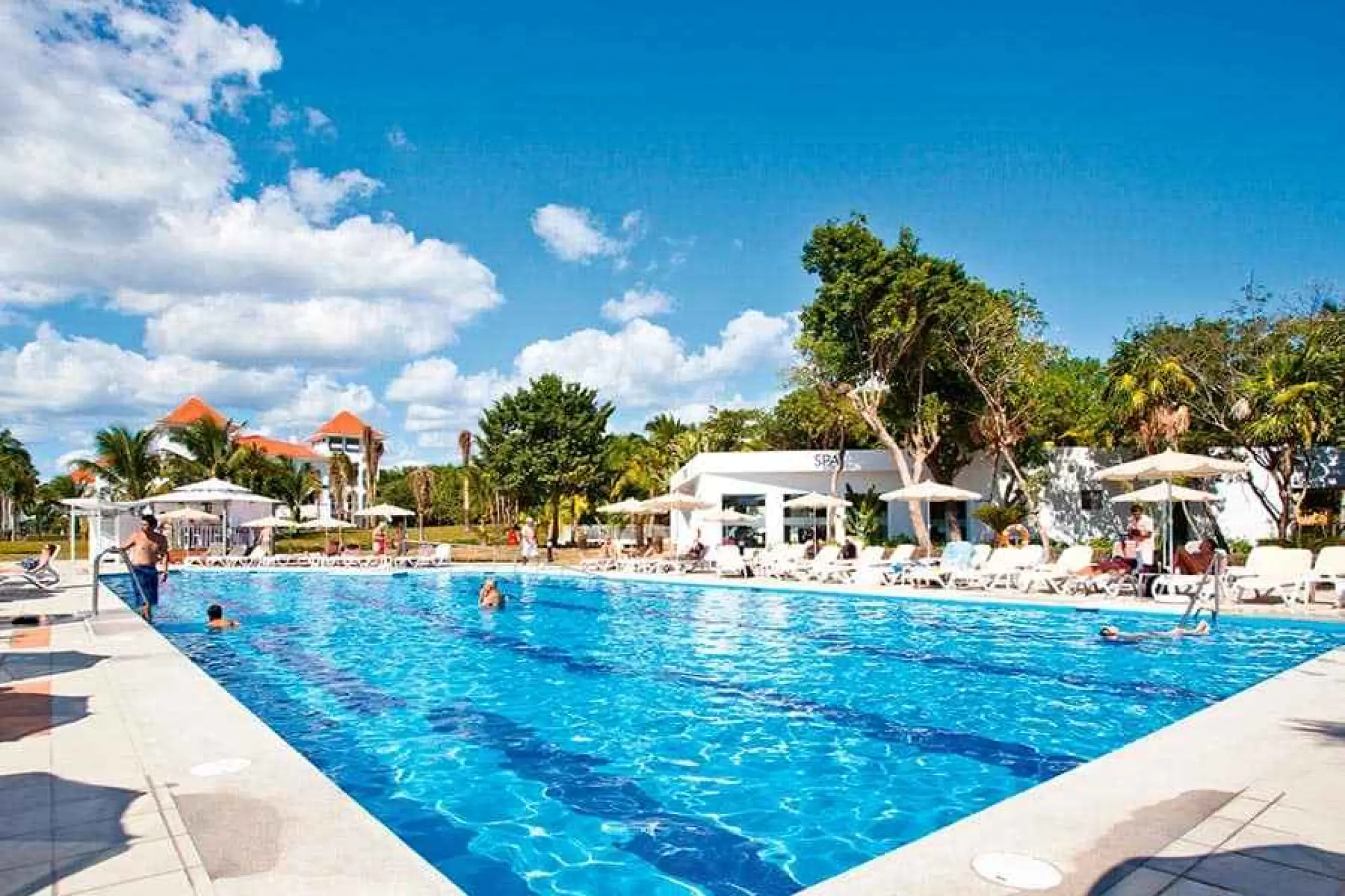 Main swimming pool with sun loungers and palm trees at Riu Palace Mexico, Playa Del Carmen