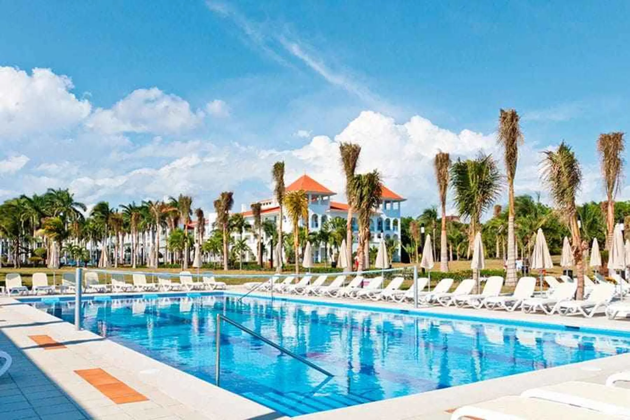 Riu Palace Mexico swimming pool with lounge chairs and palm trees, Playa Del Carmen