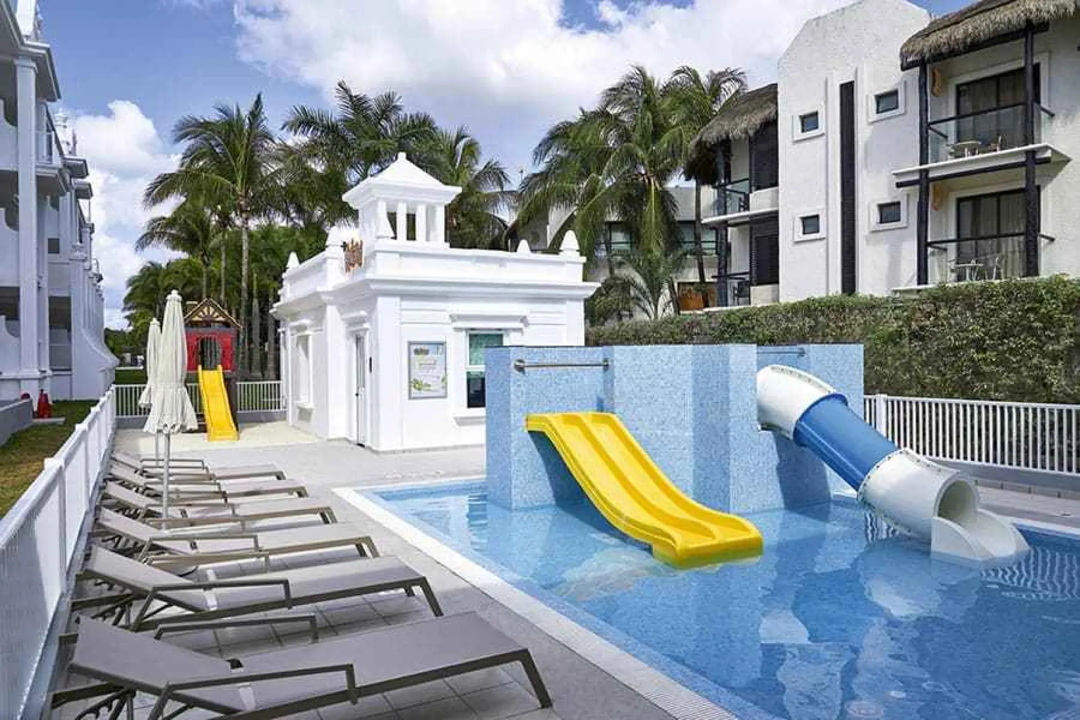 Children's pool with water slides and lounge chairs at Riu Palace Riviera Maya, Playa Del Carmen