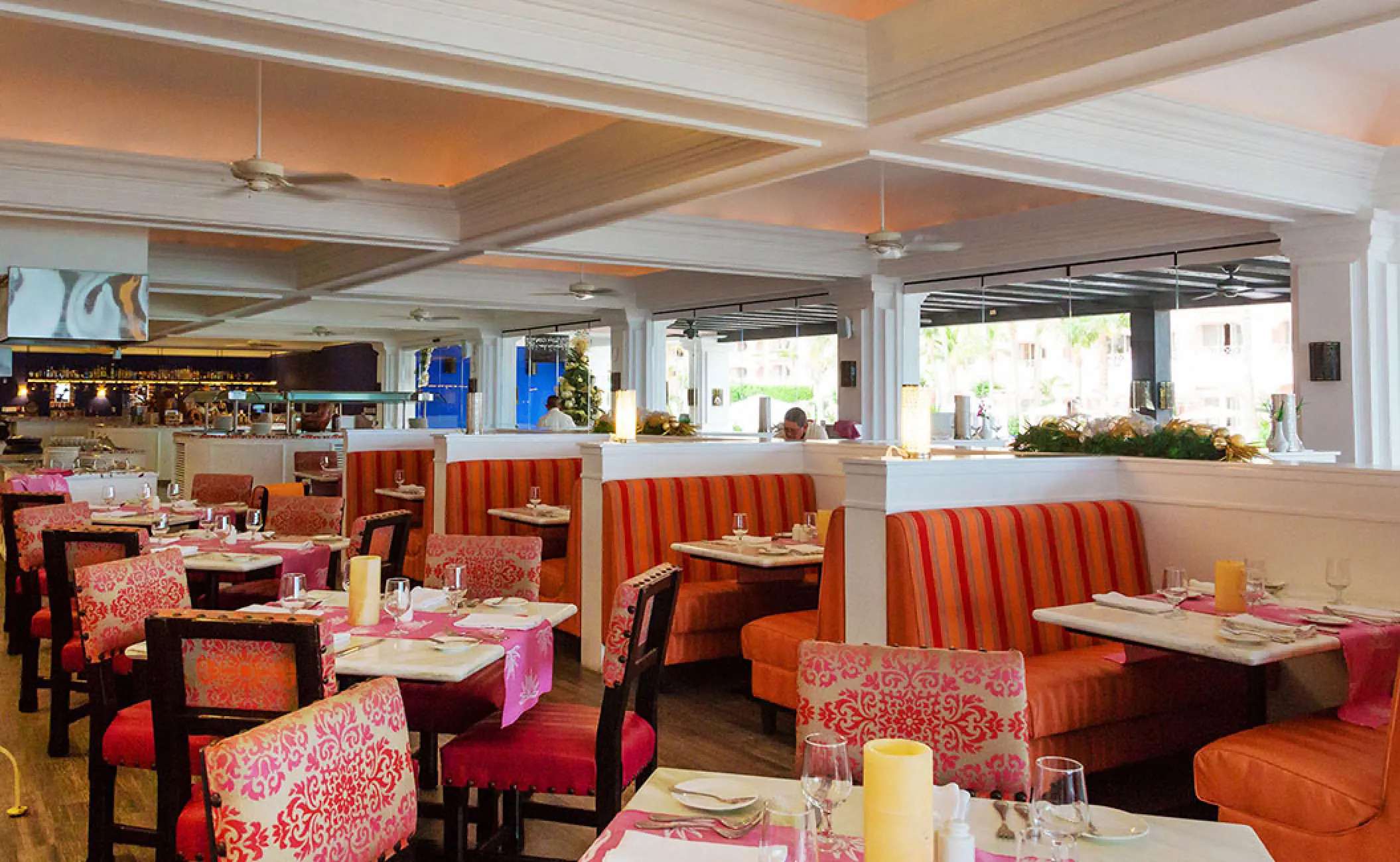 Indoor restaurant with pink and orange seating at Pueblo Bonito Rose, Cabo San Lucas