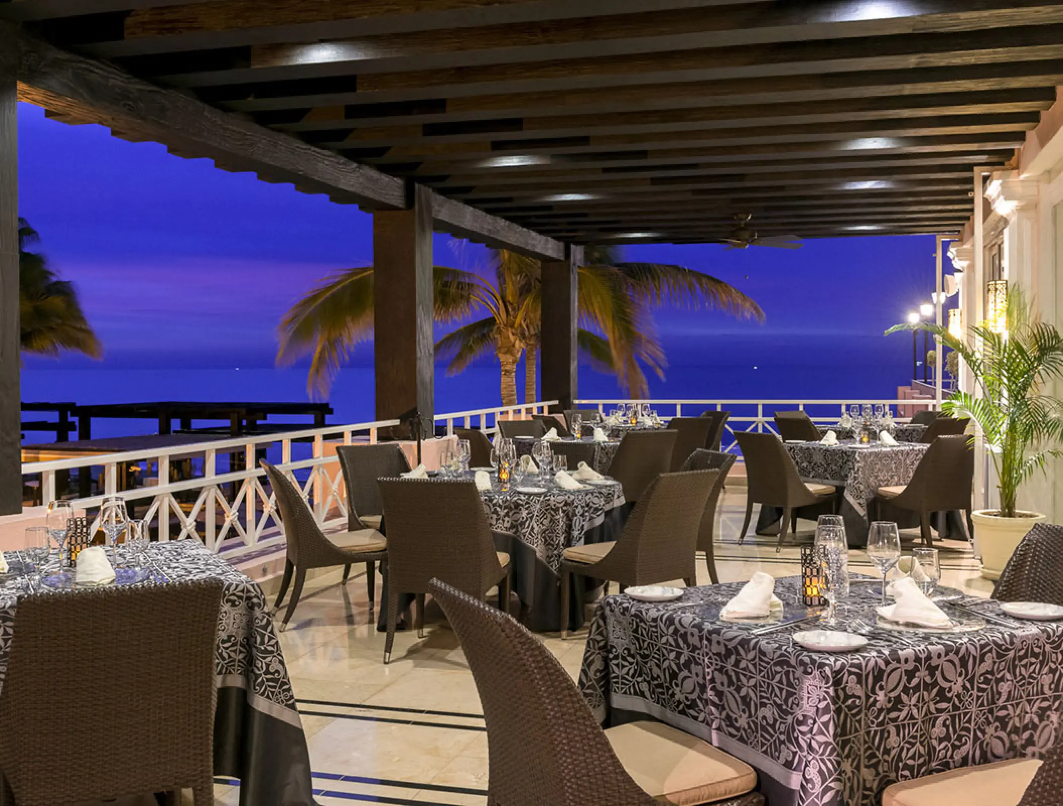 Outdoor terrace restaurant at Pueblo Bonito Rose overlooking the ocean at dusk, Cabo San Lucas