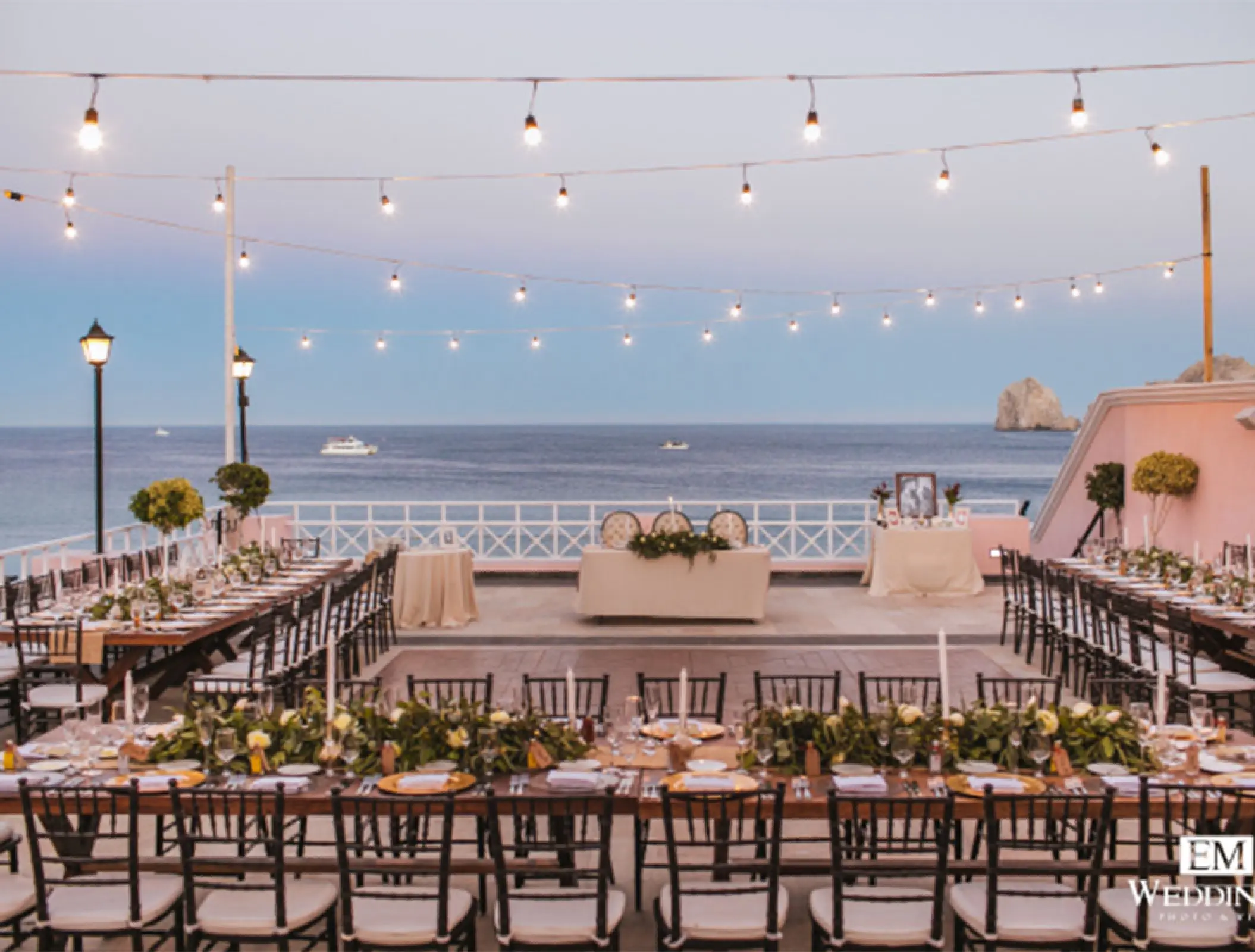 Oceanfront wedding reception setup under string lights at Pueblo Bonito Rose, Cabo San Lucas
