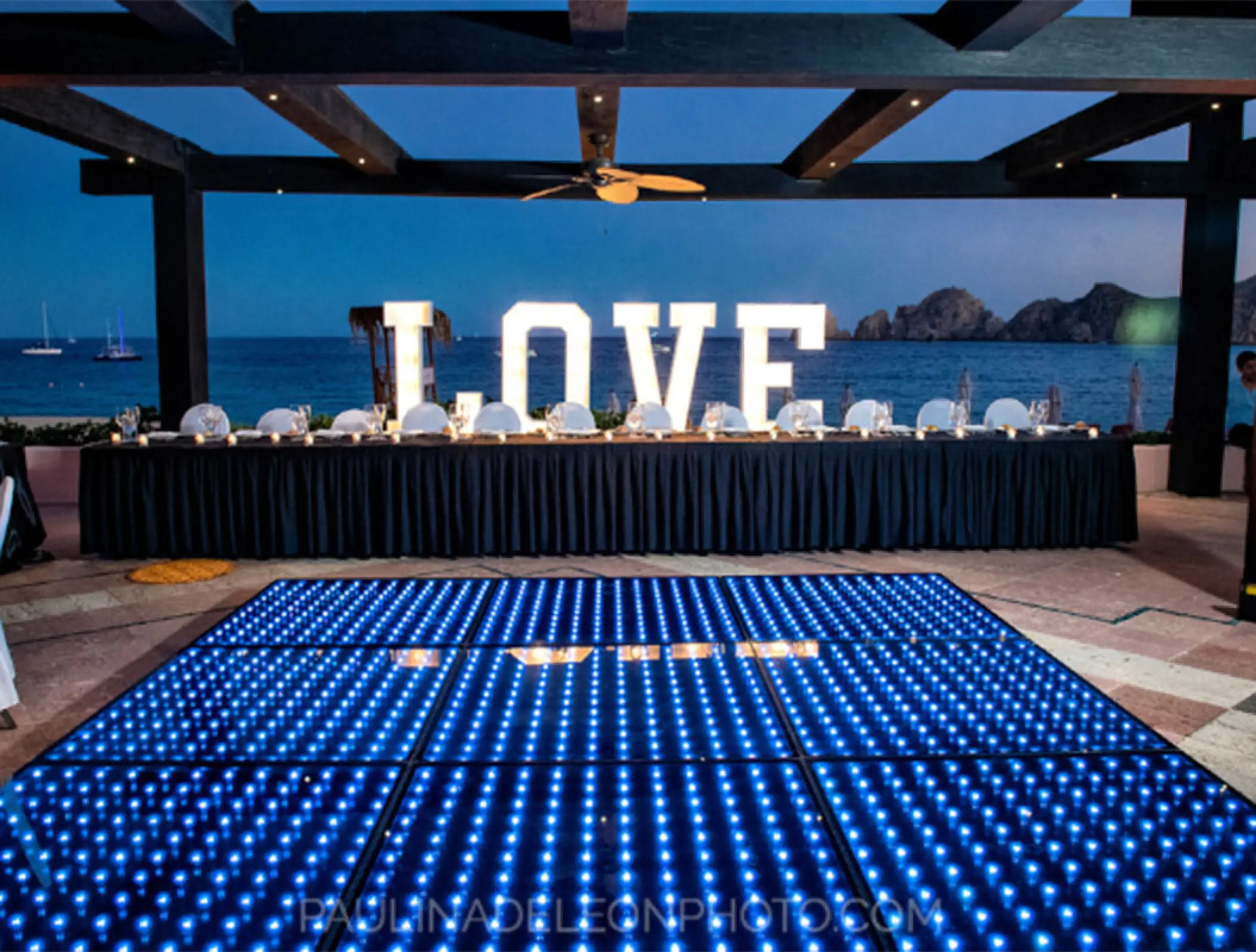 Wedding reception at Pueblo Bonito Rose with a blue LED dance floor and LOVE marquee letters, Cabo San Lucas