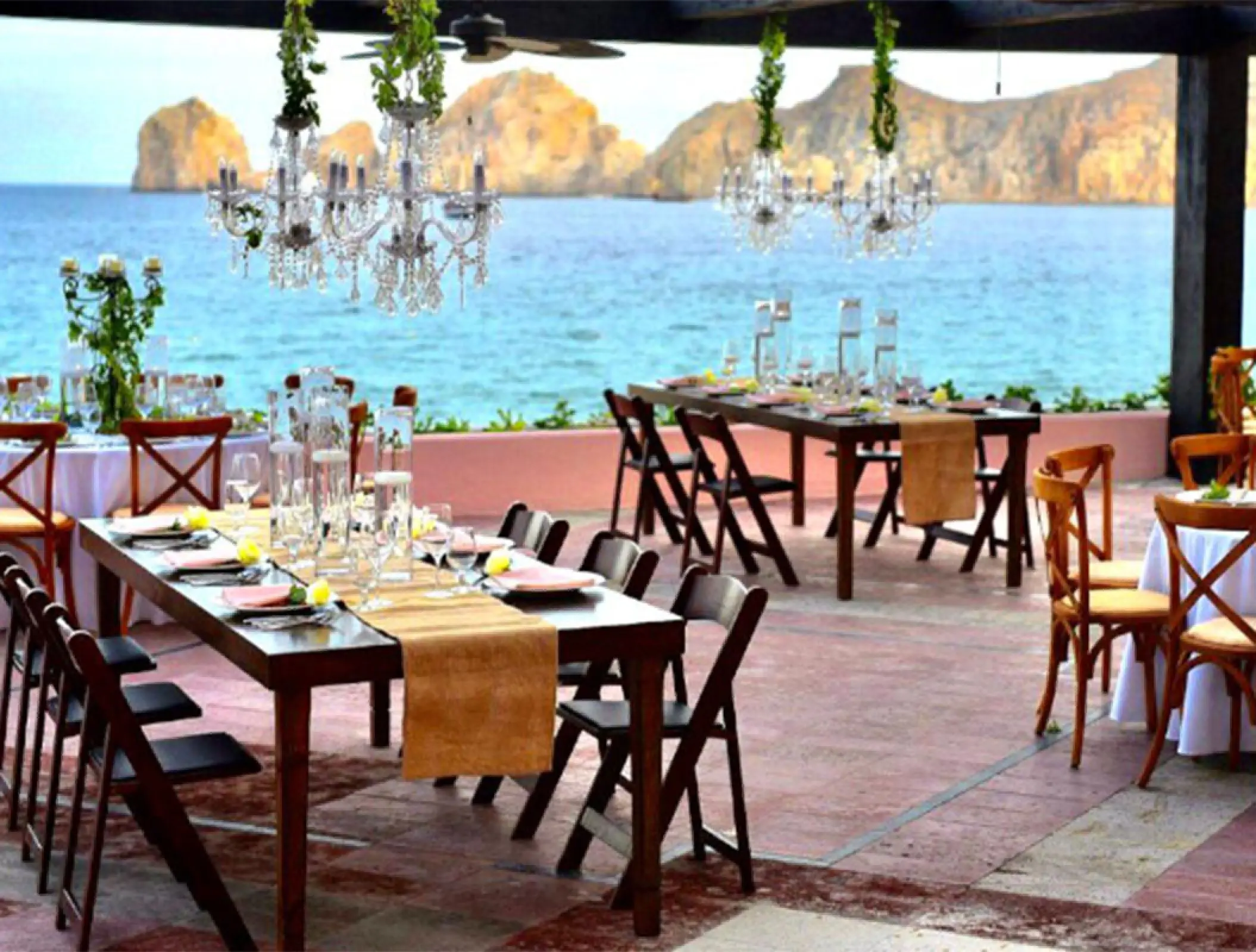 Wedding reception tables with crystal chandeliers on a terrace at Pueblo Bonito Rose, Cabo San Lucas
