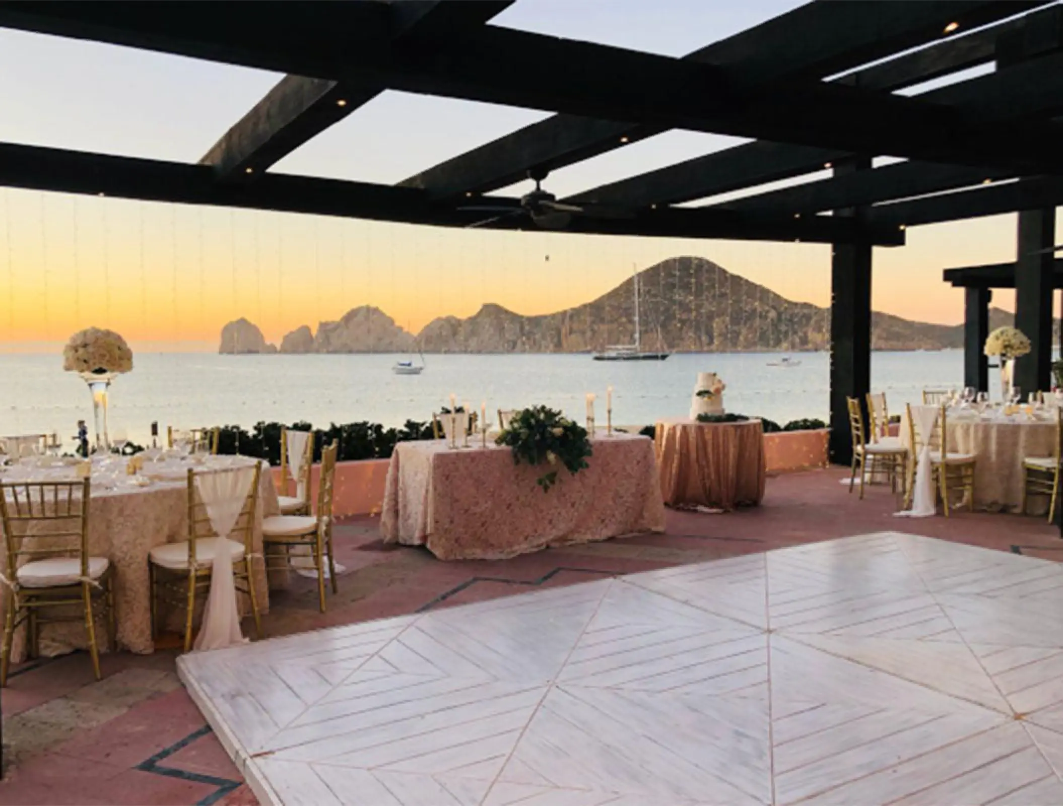 Outdoor wedding reception setup with dance floor on a terrace at Pueblo Bonito Rose, Cabo San Lucas