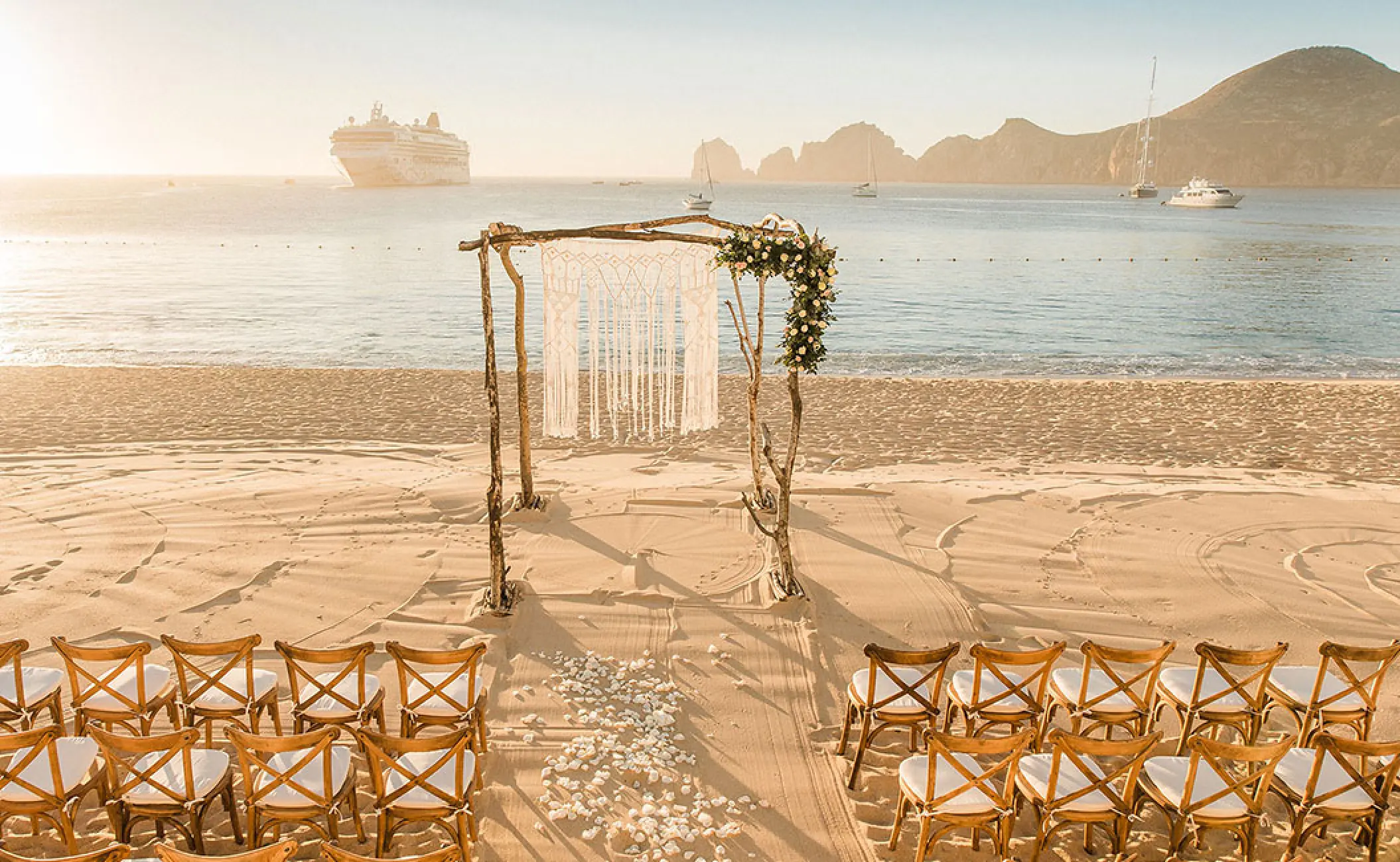 Beachfront wedding ceremony with a driftwood arch at Pueblo Bonito Rose, Cabo San Lucas