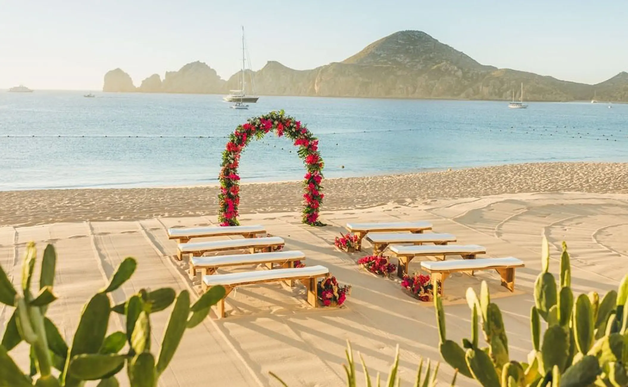 Beachfront wedding ceremony setup with floral arch at Pueblo Bonito Rose, Cabo San Lucas