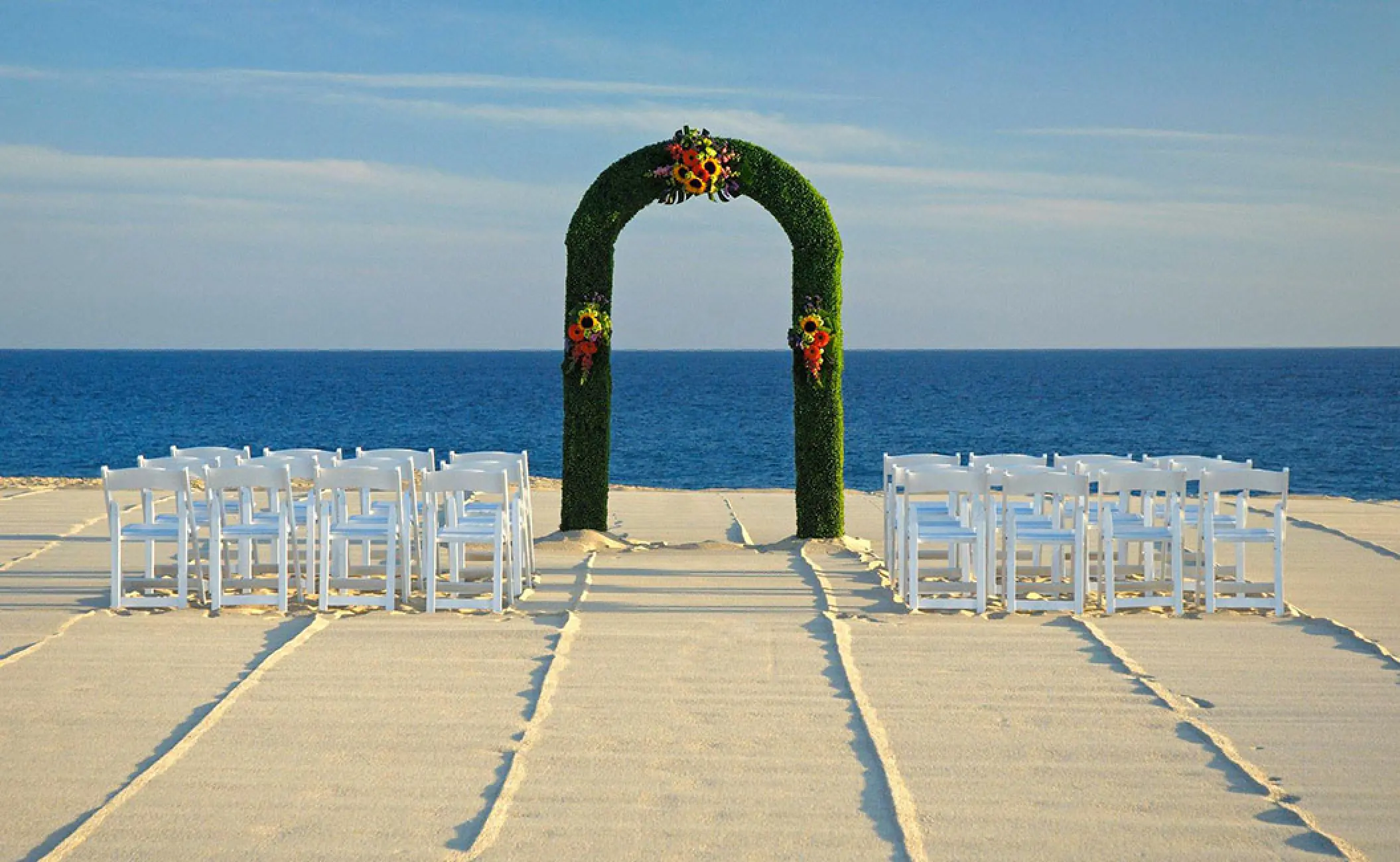 Beachfront wedding ceremony with greenery arch at Pueblo Bonito Rose, Cabo San Lucas