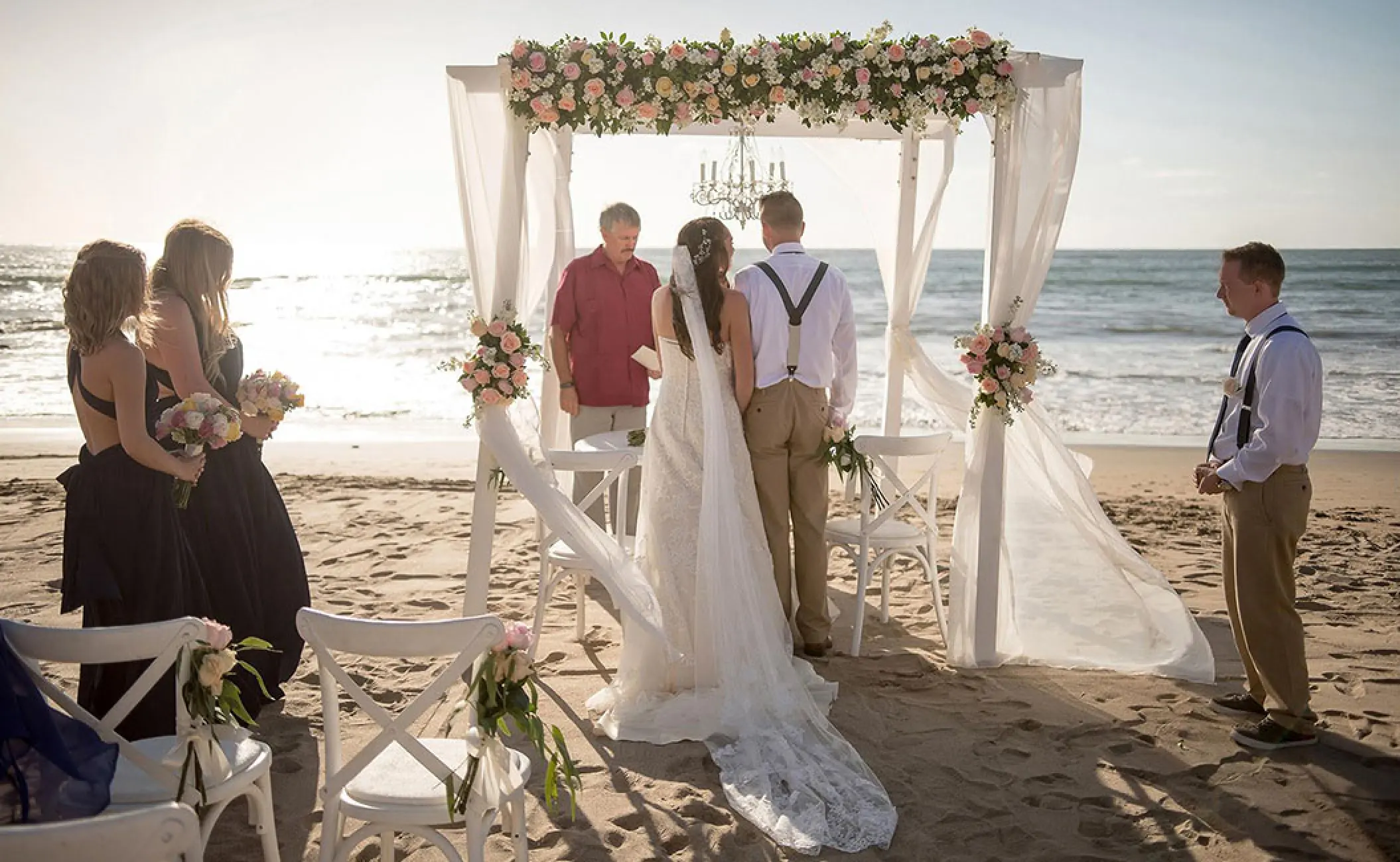 Beachfront wedding ceremony under a floral gazebo at Pueblo Bonito Rose, Cabo San Lucas